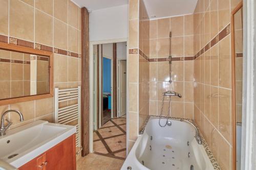 ein Badezimmer mit einer Badewanne und einem Waschbecken in der Unterkunft Cambes la Douce - Maison de vacances à la campagne in Cambes