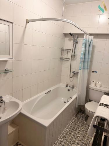 a bathroom with a tub and a toilet and a sink at Milton Road Flat 2 - TSAC in Hartlepool