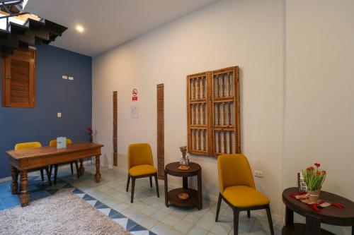 a room with a table and yellow chairs and a table at Casa Muru By Wynwood House in Cusco