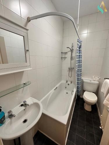 y baño con bañera, lavabo y aseo. en Milton Road Flat 1 - TSAC, en Hartlepool