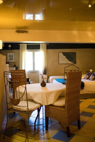 a room with a table and two chairs and a bed at In Provence Hôtel - Expérience Authentique in Venelles