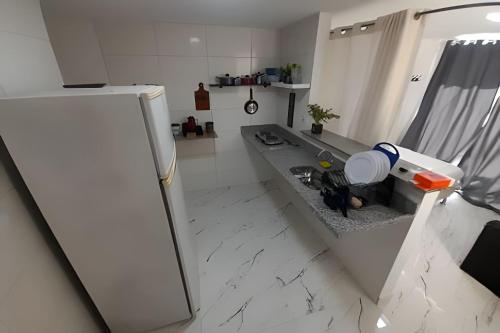 La cuisine est équipée d'un évier et d'un réfrigérateur. dans l'établissement lindo apartamento no recreio bem pertinho da praia, à Rio de Janeiro