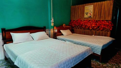 dwa łóżka w pokoju z różami na ścianie w obiekcie Let's go CAN THO - CAN THO FARMSTAY w mieście Ấp Phú Thạnh (4)