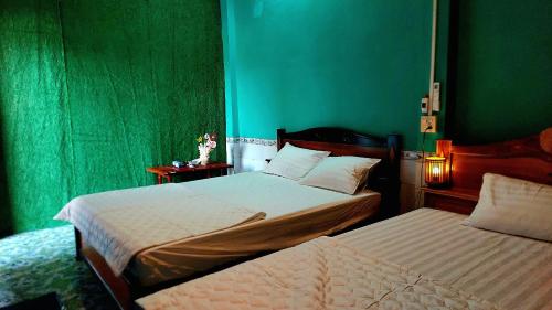 two beds in a room with green walls at Let's go CAN THO - CAN THO FARMSTAY in Ấp Phú Thạnh (4)