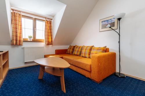 a living room with a couch and a table at Apartmány Engadin in Boží Dar