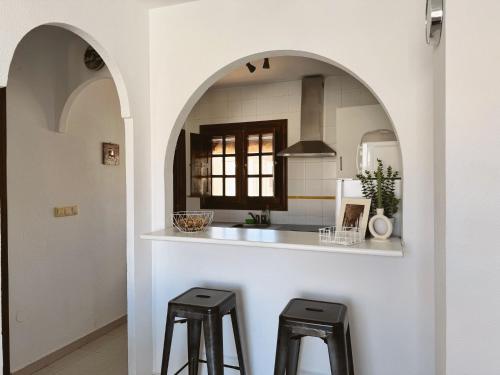 une cuisine avec un comptoir et deux tabourets dans l'établissement Apartment El Paraiso, 1 Bedroom 300M from the sea, à Torrevieja