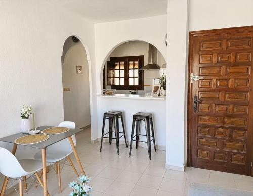- une cuisine et une salle à manger avec une table et des tabourets dans l'établissement Apartment El Paraiso, 1 Bedroom 300M from the sea, à Torrevieja