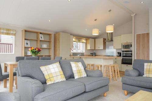 a living room with a couch and a kitchen at Lodge 70 at Riviera Bay Coastal Retreat in Brixham