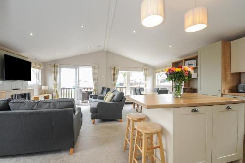 a kitchen and living room with a table and chairs at Lodge 70 at Riviera Bay Coastal Retreat in Brixham