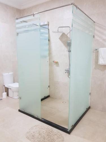 a glass shower in a bathroom with a toilet at Krotia Lodge Atimpoku 