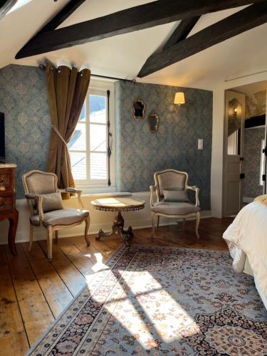 ein Schlafzimmer mit 2 Stühlen, einem Bett und einem Fenster in der Unterkunft Chambres d'hôtes du château in Boulogne-sur-Mer
