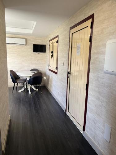 a room with a table and chairs and a door at Casas do Picoutinho in Ponte de Lima