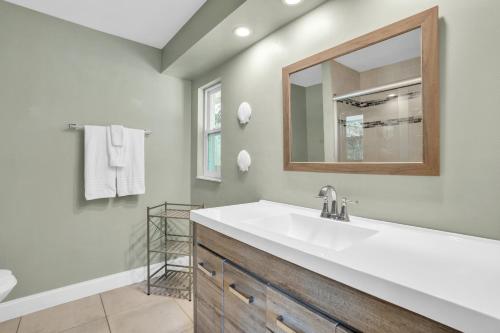 a bathroom with a sink and a mirror at Naples Single Family Pool Home - Kayak the Gordon River & Be Close to the Beach! in Naples