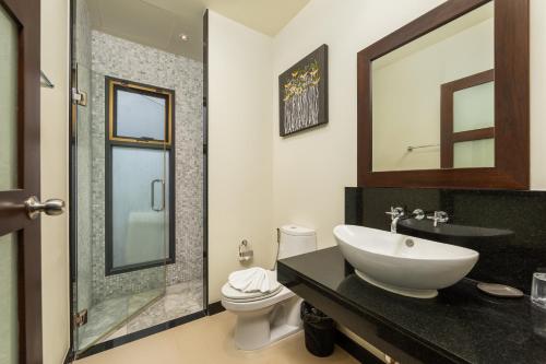 a bathroom with a sink and a toilet and a mirror at VILLA BOND| 3 Bedrooms | Private Pool | 3 min to Naiharn Beach in Rawai Beach