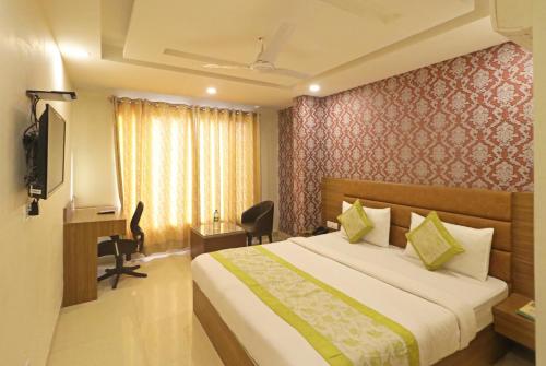 Habitación de hotel con cama y escritorio en Hotel Ronit Royal - New Delhi Airport, en Nueva Delhi