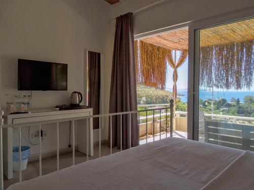 a bedroom with a bed and a large window with a view at Oza Boutique hotel in Gümüşlük