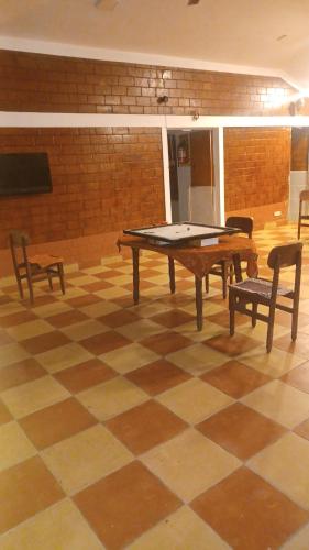 a ping pong table and two chairs in a room at Lebon's Tamilkudil in Masinagudi