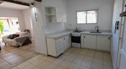 a white kitchen with a sink and a stove at Hostel Ohana in Mar del Plata