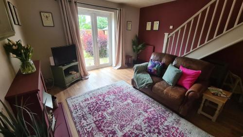 uma sala de estar com um sofá e uma televisão em The Oval by Spires Accommodation a comfortable place to stay in Swadlincote em Church Gresley