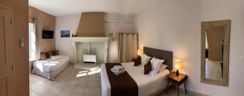 a room with two beds and a living room at Le Clos de la Tuilière in Grignan