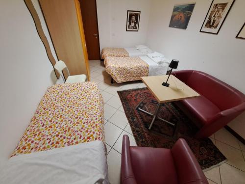 a room with two beds and a table and a couch at Lunga Via Delle Dolomiti in Calalzo