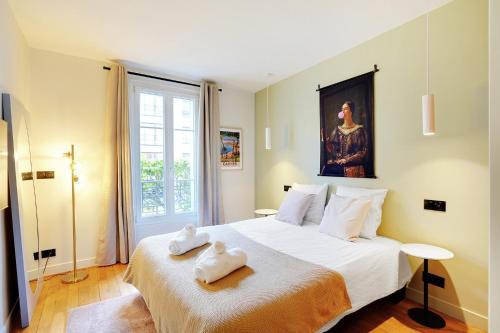 a bedroom with a large bed with towels on it at Luxury flat silly - Boulogne city center in Boulogne-Billancourt