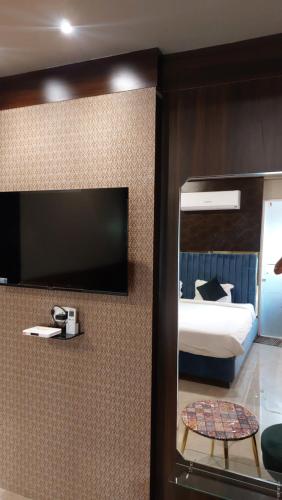 a bedroom with a bed and a mirror and a table at Hotel Grand Nidhivan in Nagpur