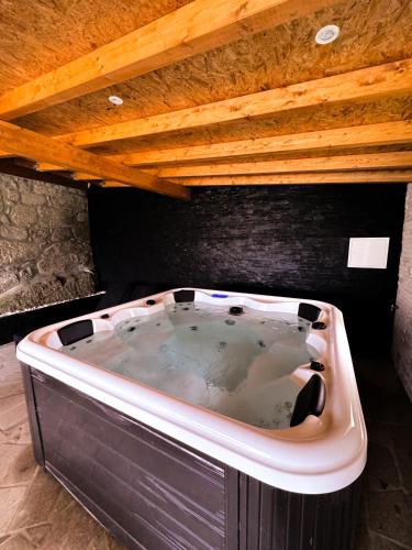 a large bath tub sitting under a wooden ceiling at DreamVille - Casa da Tapada in Arcos de Valdevez