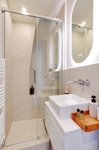 une salle de bain blanche avec un lavabo et une douche dans l'établissement Luxury flat silly - Boulogne city center, à Boulogne-Billancourt