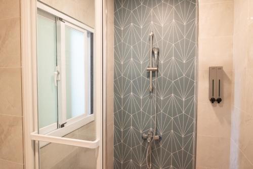a bathroom with a shower with a glass door at Welcome the sun enjoy the moon B&B in Kaohsiung