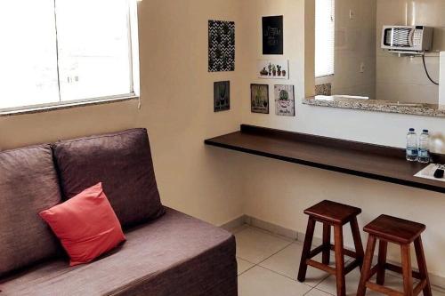 a living room with a couch and a counter at Aptos Moderno e Pratico próximo ao Teatro Paulo Moura in Sao Jose do Rio Preto