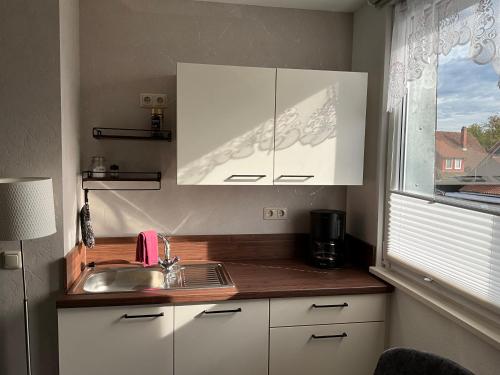 eine Küche mit einem Waschbecken und einem Fenster in der Unterkunft Apartement Meerblick in Wunstorf
