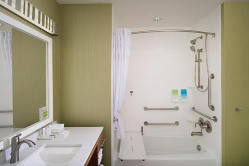 a bathroom with a tub and a shower and a sink at Home2 Suites by Hilton Denver International Airport in Denver