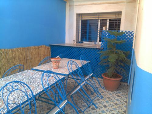 eine Terrasse mit einem Tisch und Stühlen sowie einer Topfpflanze in der Unterkunft Maison d'Hôte à Saïdia in Saidia 