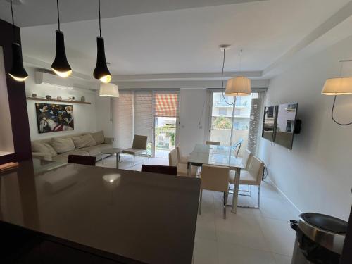 une cuisine et un salon avec une table et des chaises dans l'établissement Appartement calme familial 3 ch avec terrasses, à Juan-les-Pins