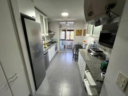 a kitchen with a refrigerator and a counter top at Eixo Atlântico in Bragança