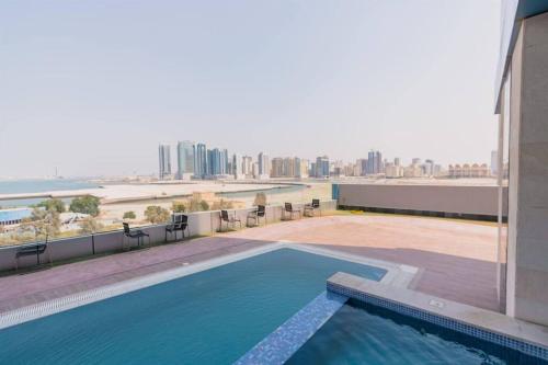 a swimming pool on top of a building with a view of the city at Era View Bahrain Luxurious 1 bedroom, Sea view and waterfront in Manama