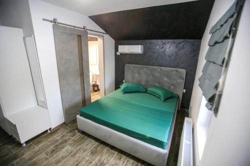 a small bedroom with a bed with green pillows at Casa Kevin in Năvodari
