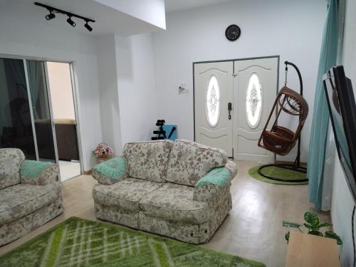 Malay Homestay di Meru, Klang في Kapar: غرفة معيشة مع أريكة وكرسي