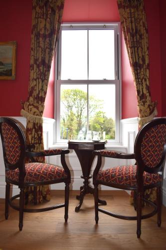 a room with two chairs and a table and a window at Tobervilla Guest House in Caherdaniel