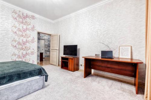 um quarto com uma cama, uma secretária e uma televisão em Promenade Expo by Keremet em Astana