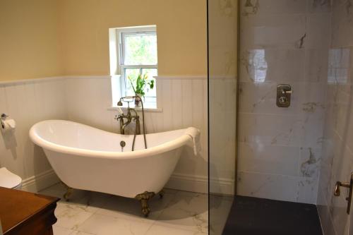 y baño con ducha y bañera. en Tobervilla Guest House en Caherdaniel