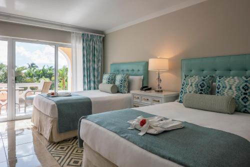 una camera d'albergo con due letti e una finestra di BodyHoliday St Lucia a Gros Islet
