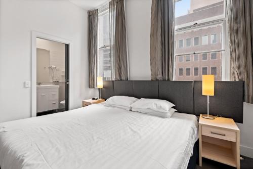 1 dormitorio con cama blanca y ventana grande en 1-Bed in CBD Perfect for a Melbourne City Break, en Melbourne