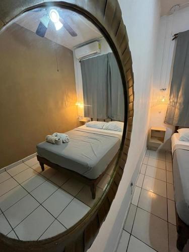 a bedroom with a bed in a round mirror at Anana Coliving in Playa del Carmen