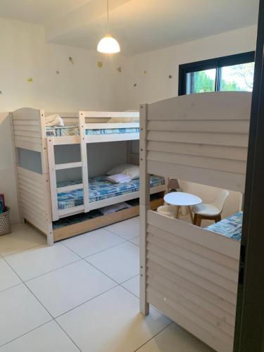 une chambre avec deux lits superposés et une table dans l'établissement Villa NEREA, à Conca