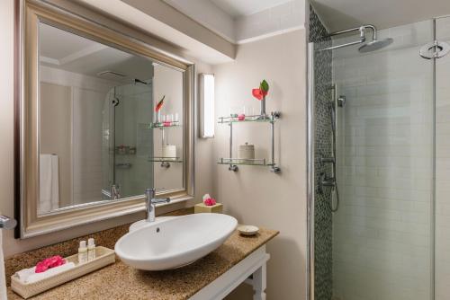 a bathroom with a white sink and a shower at BodyHoliday St Lucia in Gros Islet