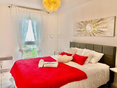 une chambre avec un grand lit avec des oreillers rouges dans l'établissement L'Eburneen YourHostHelper, à Cannes