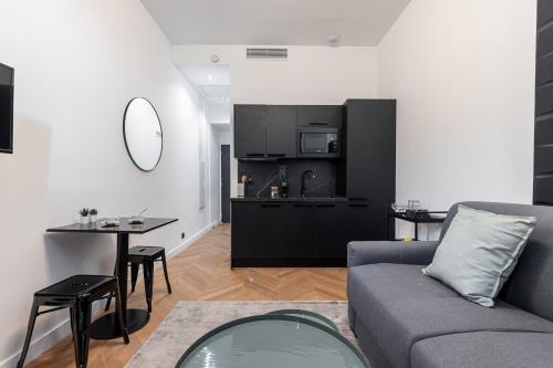 un salon avec un canapé et une table et une cuisine dans l'établissement 7 FOCH 202 - Studio contemporain en plein coeur de Nice - climatisation, à Nice