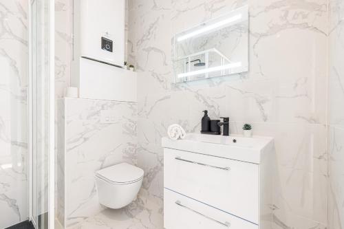 une salle de bain blanche avec des toilettes et un lavabo dans l'établissement 7 FOCH 202 - Studio contemporain en plein coeur de Nice - climatisation, à Nice